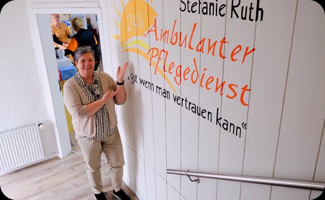 Eine Kollegin zeigt im Treppenhaus auf das Logo von AP Ruth
